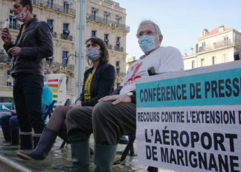 Les associations ont tenu un point presse les pieds dans l'eau pour dénoncer la montée des eaux induite par la pollution du trafic aérien (Crédit DR)