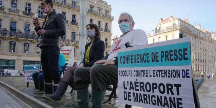 Les associations ont tenu un point presse les pieds dans l'eau pour dénoncer la montée des eaux induite par la pollution du trafic aérien (Crédit DR)