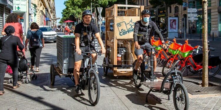 A bord de leur vélo-cargo, Théo (Agile en ville) et Enzo (indépendant) récupèrent trois fois par semaine les déchets chez une vingtaine de commerçants du quartier (crédit : JYD / Gomet')