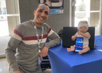 Mohamed Khalifa, le co-fondateur de Tecmoled, avec son capteur sur le front et le bandeau pour prématuré en demonstration sur une poupée (Crédit RM)