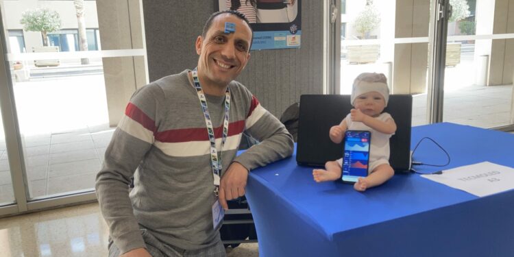 Mohamed Khalifa, le co-fondateur de Tecmoled, avec son capteur sur le front et le bandeau pour prématuré en demonstration sur une poupée (Crédit RM)