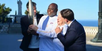 Tony Estanguet, Basile Boli, Colette Cataldo et Benoît Payan avec la torche olympique, sur l'esplanade de Notre-Dame-de-la-Garde (crédit : JRG / Gomet')