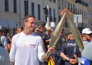 Le nageur Frédéric Bousquet récupère la flamme devant les grilles du Pharo (Crédit : JRG / Gomet')